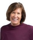 Headshot: Woman in burgundy top smiling at the camera