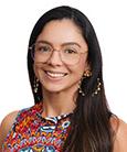 Headshot: Dark haired woman in multi-colored top smiling at the camera.