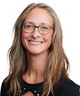 Blonde woman in a black shirt and glasses smiling at the camera. Academic Advisor